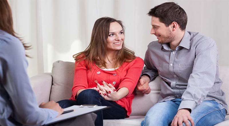 A couple sitting together on a sofa during a couples counselling session