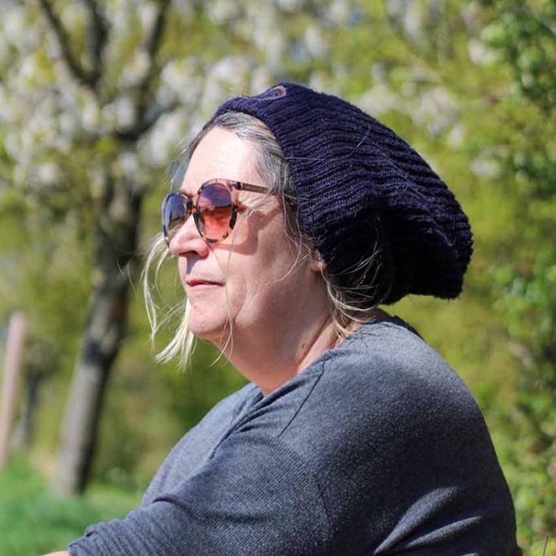 Karen Brewster, counsellor and psychotherapist, outdoors wearing a blue hat and sunglasses